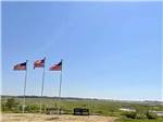 Three American flags flutter over vast landscape at SEA-VU CAMPGROUND - thumbnail