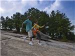 A couple holding hands walking down a mountain at STONE MOUNTAIN PARK CAMPGROUND - thumbnail