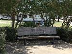 Bench with a welcome greeting and Texas flag at DALLAS NE CAMPGROUND - thumbnail
