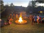 People standing around a bonfire at COOPERSTOWN SHADOW BROOK CAMPGROUND - thumbnail