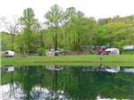 Tents and trailers on green grass near lake at SPRING GULCH RESORT CAMPGROUND - thumbnail