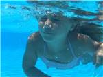 A girl swimming underwater in the pool at CROSSROADS TRAVEL PARK - thumbnail