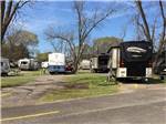 Paved RV campsites among the trees at CROSSROADS TRAVEL PARK - thumbnail