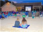 People sitting on the beach watching a movie at OCEAN VIEW RESORT CAMPGROUND - thumbnail
