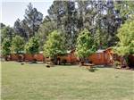 A row of rental log cabins at FAYETTEVILLE RV RESORT & COTTAGES - thumbnail