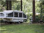 A pop up trailer in a grassy area at LAKE GEORGE RIVERVIEW CAMPGROUND - thumbnail