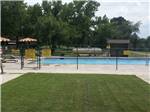 View of swimming pool with trees in the background at FORT SMITH-ALMA RV PARK - thumbnail