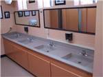 Row of clean sinks in public bathroom at FORT SMITH-ALMA RV PARK - thumbnail