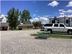 A picnic table at a gravel RV site at DEER LODGE A-OK CAMPGROUND - thumbnail