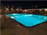 Lit up pool at nighttime at HITCHIN' POST RV PARK - thumbnail