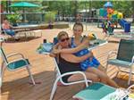 Mother and daughter hanging out pool side at ATLANTIC SHORE PINES CAMPGROUND - thumbnail