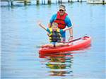 A kid on a kayak with his father at SUN OUTDOORS CAPE CHARLES - thumbnail