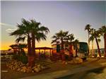 A motorhome parked in a gravel site at sunset at FOUNTAIN OF YOUTH SPA RV RESORT - thumbnail