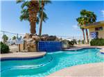 Pool view with rock structure and waterfall at FOUNTAIN OF YOUTH SPA RV RESORT - thumbnail