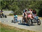 A family riding on peddle carts at CASINI RANCH FAMILY CAMPGROUND - thumbnail