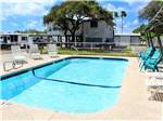 Pool with outdoor seating at PADRE PALMS RV PARK - thumbnail