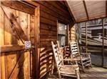 Wooden rocking chairs on a porch at MOUNTAINEER CAMPGROUND - thumbnail