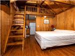 Interior view of cabin with bed and loft at MOUNTAINEER CAMPGROUND - thumbnail