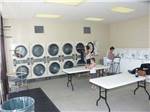 Two ladies doing laundry at TRADERS VILLAGE RV PARK - thumbnail
