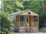 Cabin with porch surrounded by trees at ROUND TOP CAMPGROUND - thumbnail