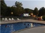 Kids in the swimming pool enjoying a movie on a large screen at NATURES CAMPSITES - thumbnail