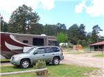 A car and motorhome in an RV site at SPRUCE LAKE RV RESORT - thumbnail