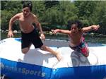 Boys jumping off a trampoline on the water at OTTER LAKE CAMP RESORT - thumbnail