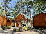 A row of rustic rental log cabins at PINE ACRES FAMILY CAMPING RESORT - thumbnail