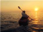 A person paddling towards the sun at FRISCO WOODS CAMPGROUND - thumbnail
