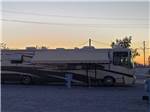 Long motorhome at campsite during dusk at 88 SHADES RV PARK - thumbnail