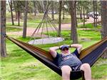 A man sitting in a hammock at BEAVER LAKE CAMPGROUND - thumbnail