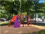 Colorful play structure with climbing and rope obstacles at HOLIDAY PARK CAMPGROUND - thumbnail