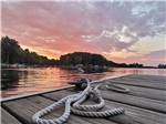 Rope tied to a cleat on a wooden dock overlooking a lake at HOLIDAY PARK CAMPGROUND - thumbnail