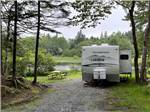 A travel trailer parked in a gravel site at HALIFAX WEST KOA - thumbnail