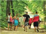 A family walking through the trail leading to waterpark at PLYMOUTH ROCK CAMPING RESORT - thumbnail