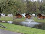 A view of the camping cabins along a lake at HUNTINGTON FOX FIRE KOA - thumbnail