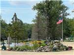 Landscaped area with American flag at BER WA GA NA CAMPGROUND - thumbnail