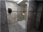 Shower with gray stone walls and glass shower door at INDIAN HEAD CAMPGROUND - thumbnail