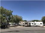 Campers in campsites under a blue sky at HIGHLANDS RV PARK - thumbnail