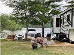 An RV site with a wooden patio by the water at AUGUSTA-WEST LAKESIDE KAMPGROUND - thumbnail