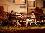Couple enjoying the evening outside their RV at LAKE PARK CAMPGROUND & COTTAGES - thumbnail