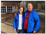 A smiling couple in blue jackets at CARIBOU RV PARK - thumbnail