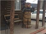 A wooden bear holding a welcome sign at AB CAMPING RV PARK - thumbnail