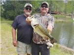 Two men showing caught fish at PARADISE LAKE FAMILY CAMPGROUND - thumbnail