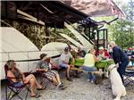 A group of people eating along side of a motorhome at SUMMER HOUSE PARK - thumbnail