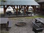 A fire pit with picnic tables at GOLDEN MUNICIPAL CAMPGROUND - thumbnail