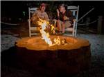 A couple sitting next to a burning fire at CHOKOLOSKEE ISLAND RESORT - thumbnail