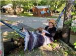 A woman and a dog in a hammock  at BLUE MOUNTAIN CAMPGROUND - thumbnail