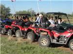 Row of people in red ATVs at ARIZONIAN RV RESORT - thumbnail