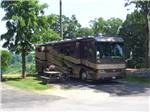 Big rig parked in a site with picnic table at ASHEVILLE BEAR CREEK RV PARK - thumbnail